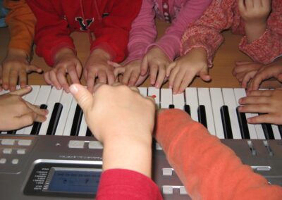 viele Kinderhände auf einem Keyboard
